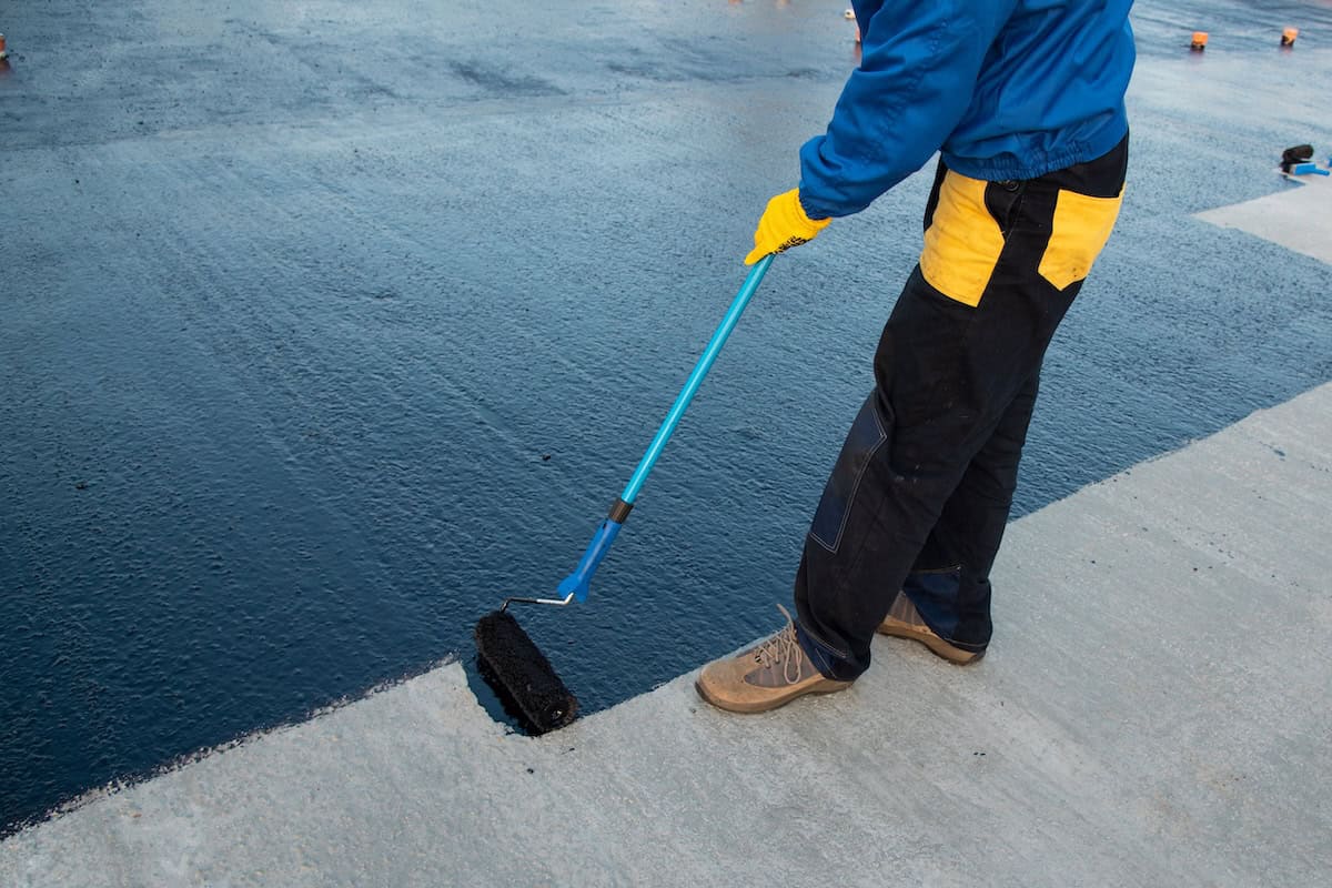 Waterproofing coating being applied to flat roof