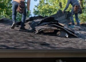 Tearing off roofing that was damaged by a storm