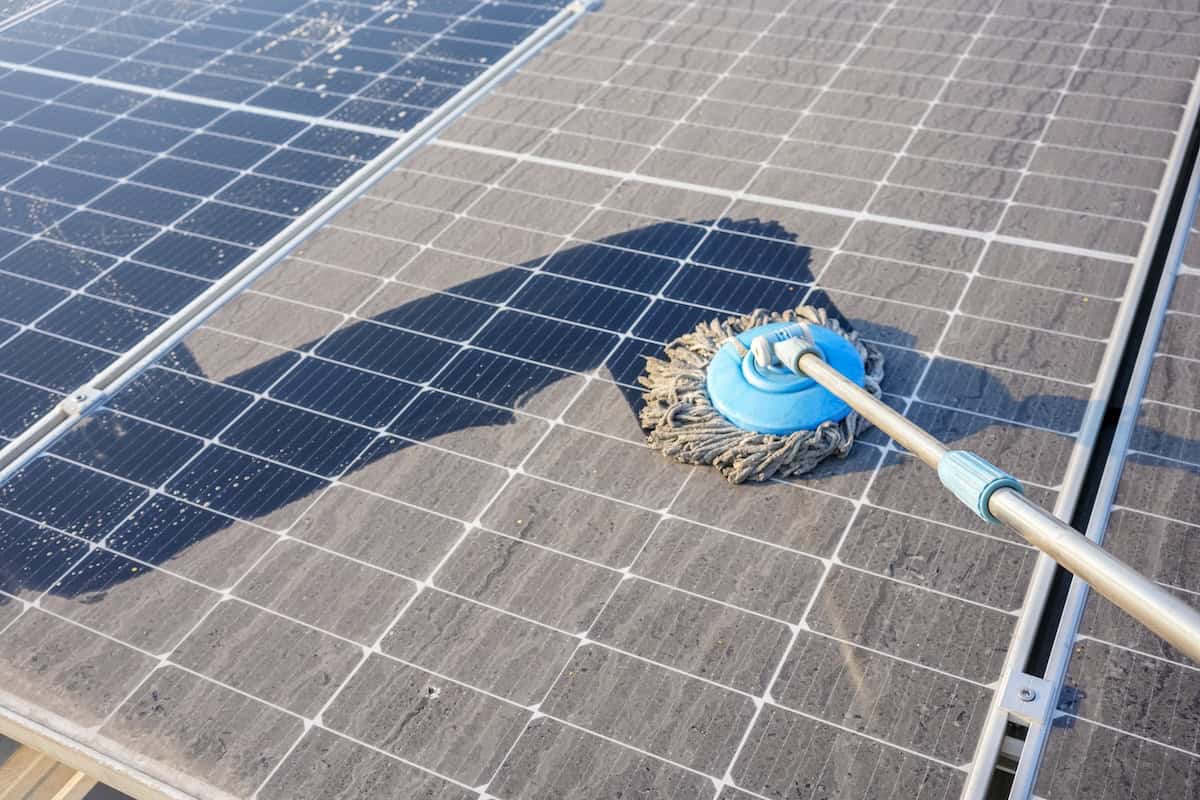 Using a mop to clean roof tiles