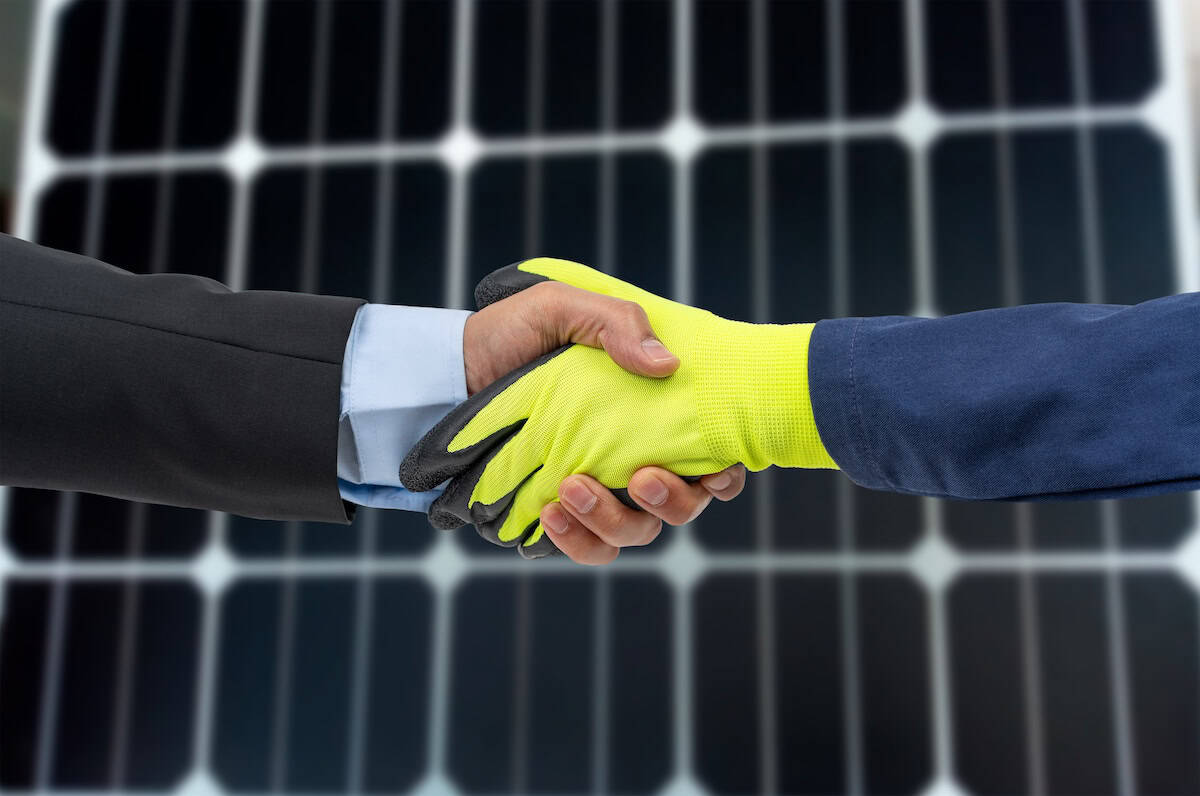 Engineer and customer shaking hands after successful installation of solar panels on a house roof, renewable energy and sustainable lifestyle concept