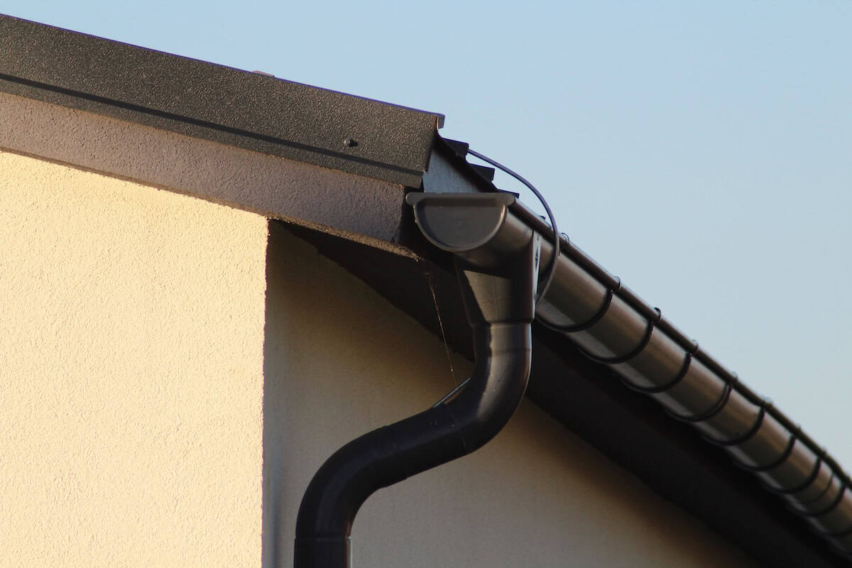black metal gutter that matches roofing
