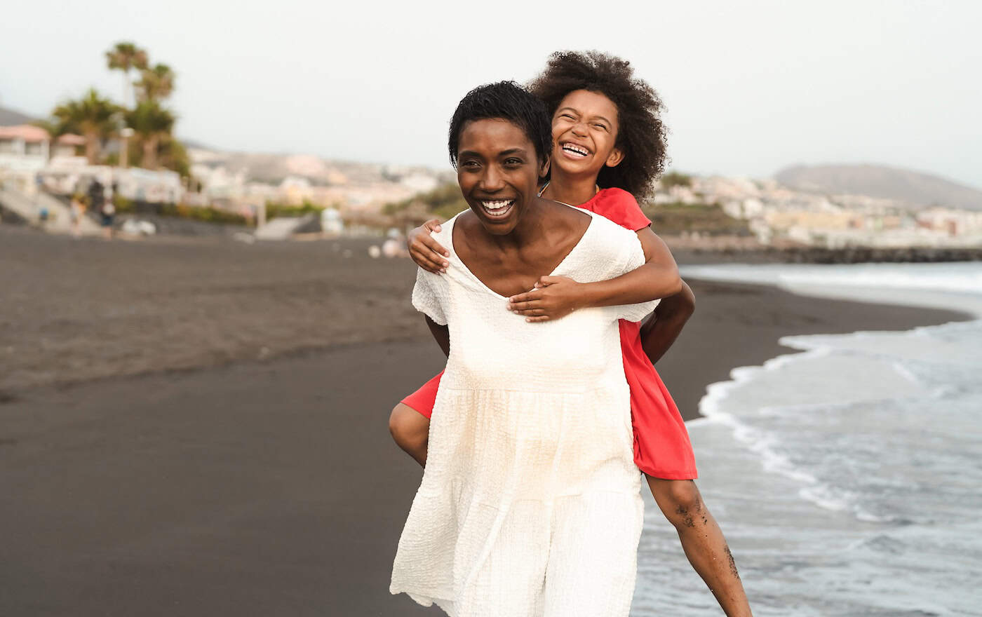 Happy family on the beach during summer holidays - Afro American people having fun on vacation time - Parents love and travel lifestyle concept