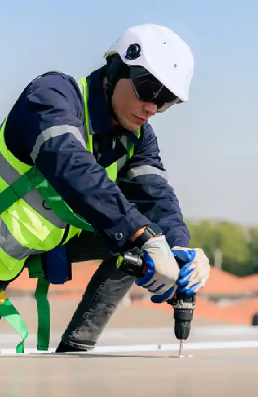Cleaner with a pressure washer on the roof of a house. Roof washing cleaning includes: tiles, shingles, and focusing on removing moss and weeds.